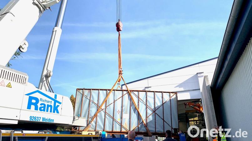 Dieser Kran hat am Montagvormittag in Flossenbürg 42 Tonnen am Haken. In dem Container befindet sich das größte Bauteil einer Thixo-Molding-Maschine, die den Standort von 595 Solutions weiter nach vorne bringen soll. Bild: Gabi Schönberger