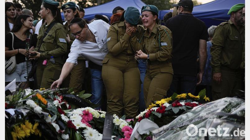 Trauernde versammeln sich bei der Beerdigung um die Gräber von Yam Goldstein und ihrem Vater Nadav. Er und seine Tochter wurden am 7. Oktober in ihrem Haus im Kibbuz Kfar Aza nahe der Grenze zum Gazastreifen von Mitgliedern der Hamas ermordet. Bild: Ariel Schalit, dpa