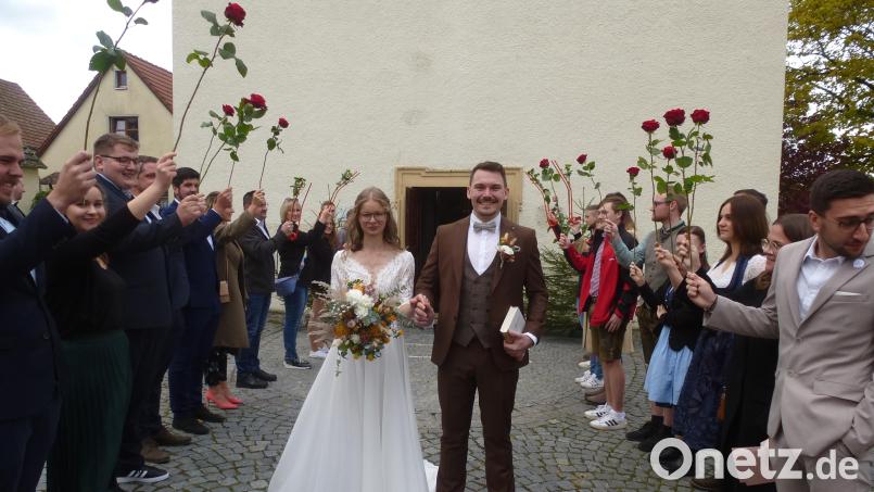 Lukas Bäumler und Rebecca Luber schreiten nach ihrer Hochzeit durch das Rosenspalier ins Eheglück. Bild: bk