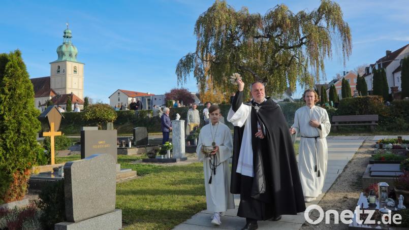 Pfarrer Josef Irlbacher segnet auf dem Dreifaltigkeitsfriedhof in Amberg an Allerheiligen die Gräber. Bild: Wolfgang Steinbacher