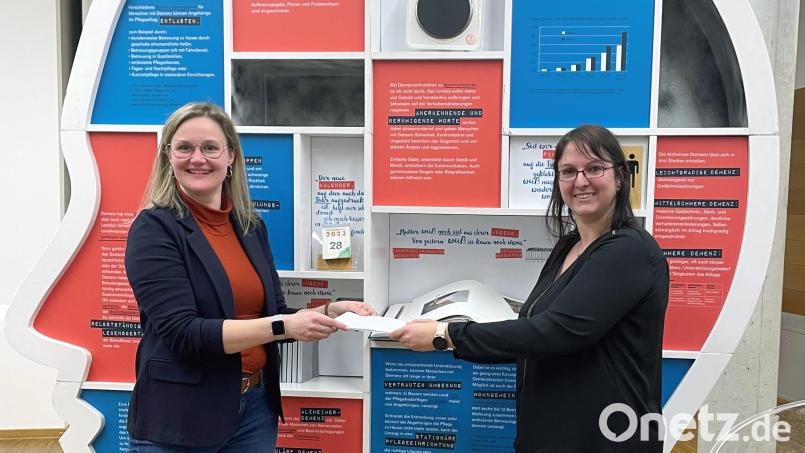 Sarah Lebek (rechts) übergibt die Spende an Kathrin Fischer als Vertreterin der Geschäftsstelle des Bayerischen Demenzfonds. Bild: LfP/Linda Hartmann/exb