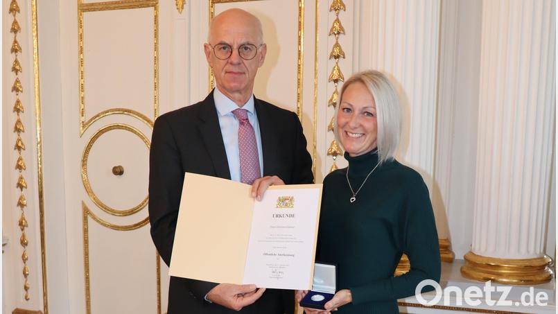 Regierungspräsident Walter Jonas ehrt Christina Brumer aus dem Schwandorfer Ortsteil Bubach für die Erstversorgung eines verletzten Motorradfahrers. Sie erhält dafür eine öffentliche Anerkennungsurkunde mit Medaille. Bild: Regierung der Oberpfalz/Stühlinger-Weinhändler/exb
