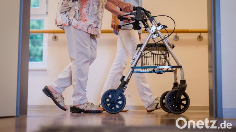 Eine Pflegekraft geht in einem Pflegeheim mit einer älteren Dame über einen Korridor. Im Gesundheitswesen sind im Landkreis Schwandorf im Oktober besonders viele freie Stellen gemeldet worden. Symbolbild: Christoph Schmidt/dpa