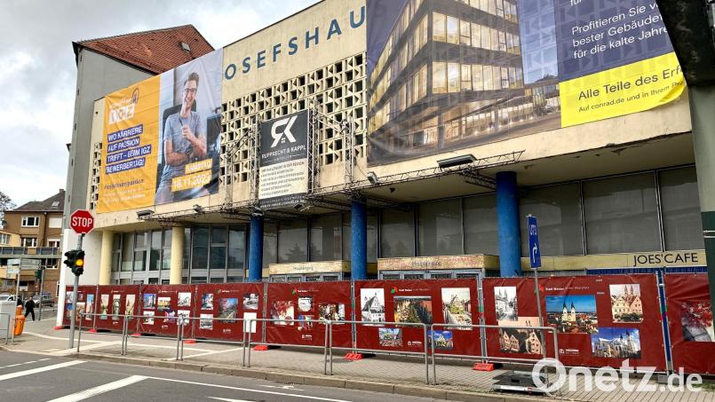 Ein roter Bauzaun mit Bildern der Stadt dient künftig als Sichtschutz für das von Taubendreck verunstaltete Weidener Josefshaus. Bild: Gabi Schönberger