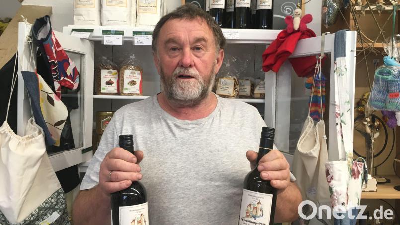 Josef Schwandner, Geschäftsführer des Dorfladens, ist unschlüssig. Schmeckt der weiße oder der rote Versöhnungstrunk besser? Bild: ihl