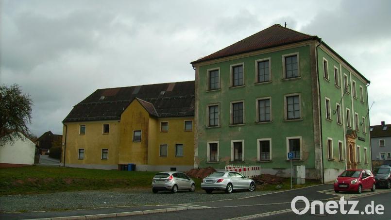 Schluss mit der Schotterwüste: Begrünt und barrierefrei soll sich der Klosterhofparkplatz (links) in naher Zukunft präsentieren. Die symmetrische Ästhetik der Westfassade des &quot;Hauses der Heimat&quot; (rechter Bildrand) soll erhalten bleiben. Die Renovierungsbedürftigkeit des gut 120 Jahre alten Gebäudes ist unübersehbar. Bild: bjp