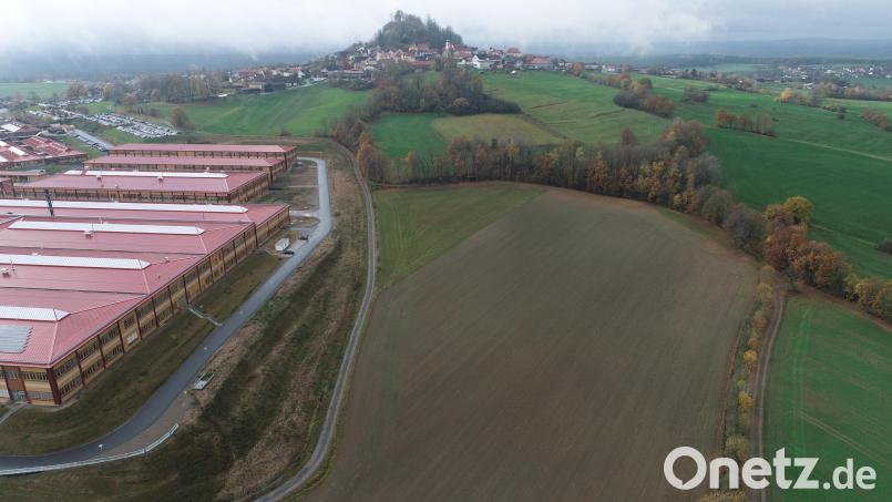 Die freie, bräunlich erscheinende Fläche wird bis zur oben zu sehenden Baumreihe für eine Erweiterungsbau der Firma Witron genutzt, Das neue Gebäude erhält zwei Verbindungen zum linken größeren Betriebsgebäude. Bild: bey