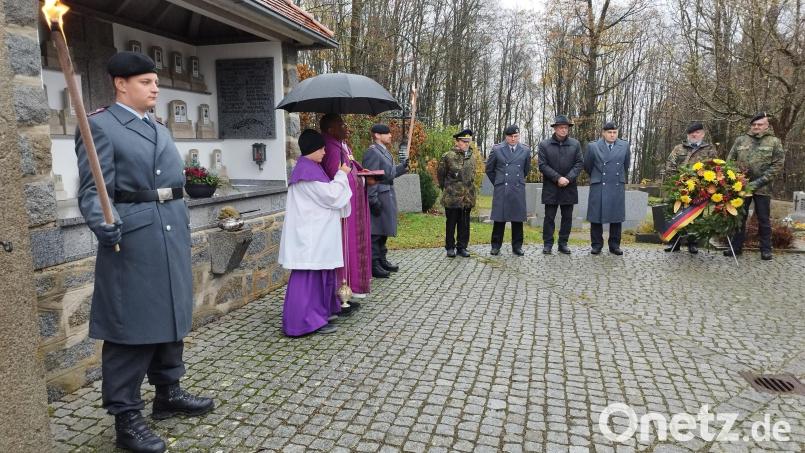 Bürgermeister Schauer, Mitglieder der SRK, der Feuerwehr und der Bundeswehr versammeln sich am Thansteiner Kriegerdenkmal, um mit Pfarrvikar Emmanuel Ogbu der Kriegsopfer zu gedenken. Bild: dl