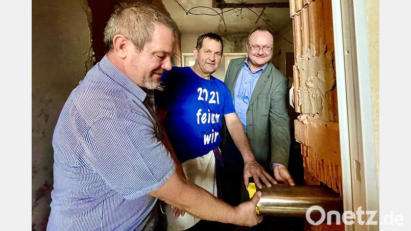 Stecken die Metallkapsel mit der Urkunde in das bestehende Grundsteinloch (von links): Projektleiter Reinhard Seidl, Marktrat Stefan Blind und Bürgermeister Uwe König. Bild: Krones