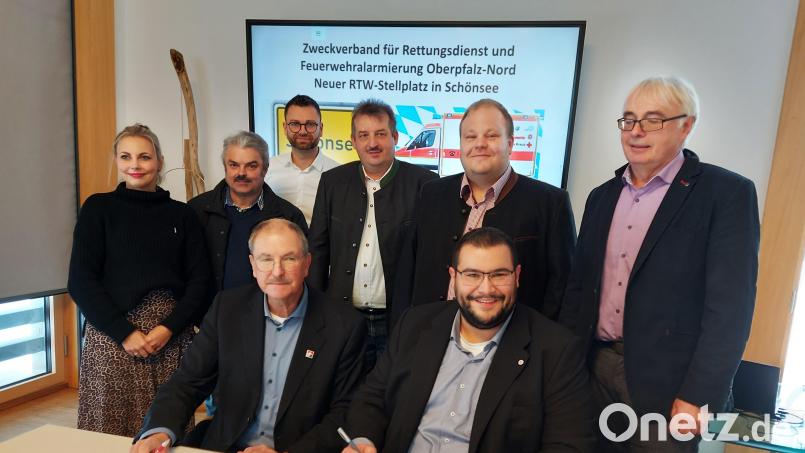 Der Geschäftsleiter des Zweckverbands für Rettungsdienst und Feuerwehralarmierung, Alfred Rast (links), und Tobias Karl (rechts) von der Johanniter-Unfall-Hilfe e.V. unterzeichnen den Vertrag für den Schönseer Rettungswagen. Die drei Bürgermeister freuen sich auch über diese Aufwertung ihrer Stadt. Bild: lg