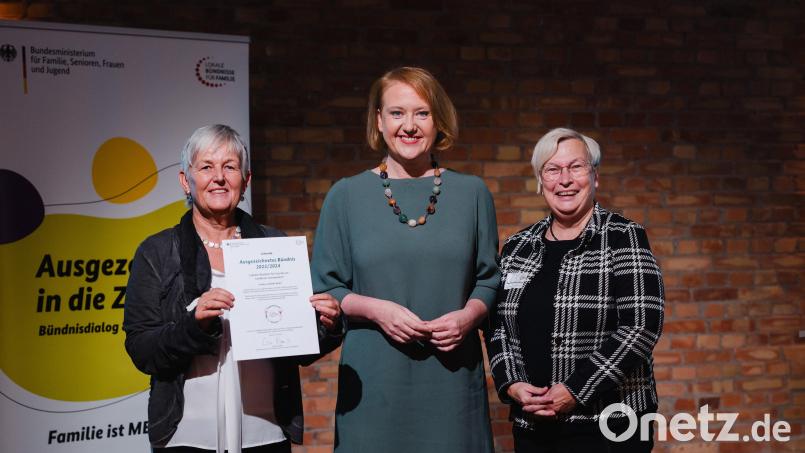 Helga Forster und Dorothea Seitz-Dobler nehmen als Vertreterinnen des Lokalen Bündnis für Familien Schwandorf von Bundesministerin Lisa Paus (Mitte) eine Auszeichnung für ihr Engagement entgegen. Bild: Nils Hasenau/exb