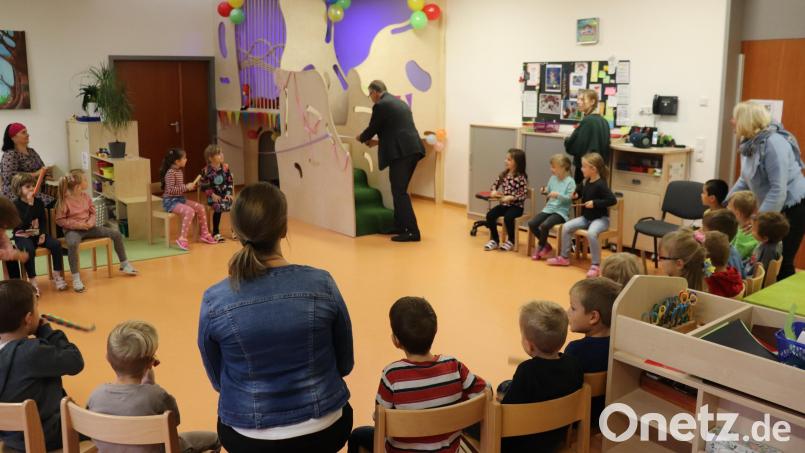 Gespannt beobachten die Schlauen Füchse, ihre Erzieherinnen sowie Silvia Markowski (rechts) Bürgermeister Franz Stahl beim Durchschneiden des Einweihungsbandes für das neue Spielhaus. Bild: Stadt Tirschenreuth/exb
