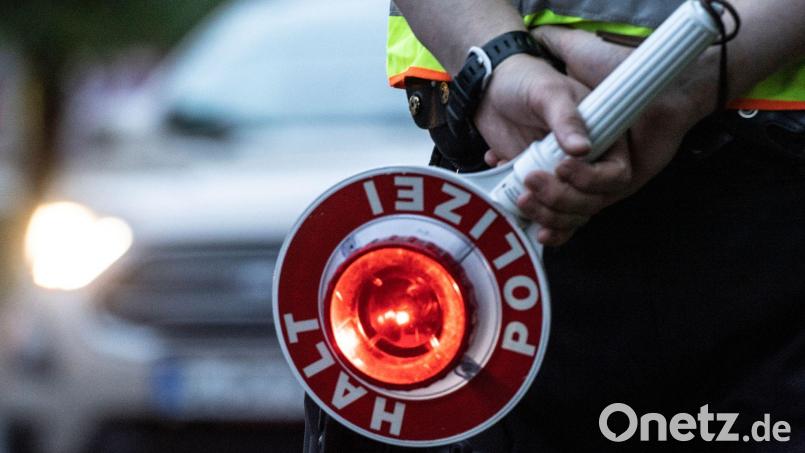 Ein Polizist hält bei einer Verkehrskontrolle eine Winkerkelle in der Hand. Symbolbild: Paul Zinken/dpa