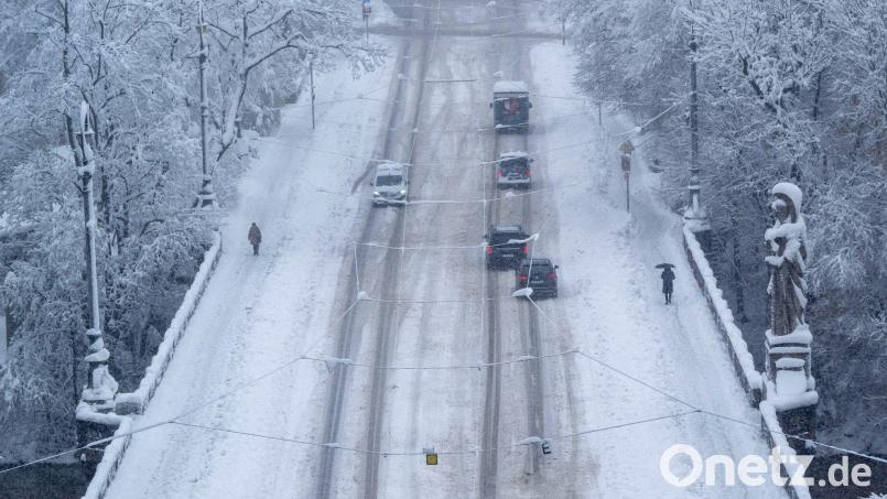 Passanten und Autos bahnen sich ihren Weg über die Maximiliansbrücke. Bild: Peter Kneffel/dpa