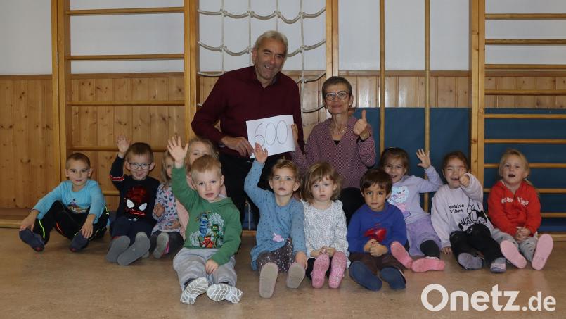 Umrahmt von Kindern: Die Leiterin der evangelische Kindertagesstätte Loderhof, Sigrid Zylowski (rechts) freut sich über die Spende von Günter Haller (links). Bild: mfh