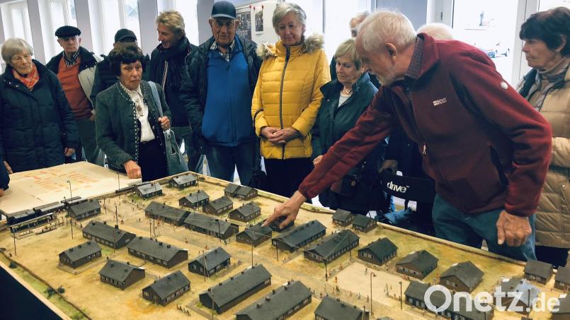 In den Mittelpunkt beim Besuch einer Delegation aus Augsburg und Mittelfranken rückte das Modell des ehemaligen Grenzdurchgangslagers in Wiesau. Die Details erläuterte der Wiesauer Historiker Adalbert Busl (rechts). Zu den vielen, die dort lebten, gehört auch Anita Donderer aus Augsburg (Zweite von links). Bild: wro