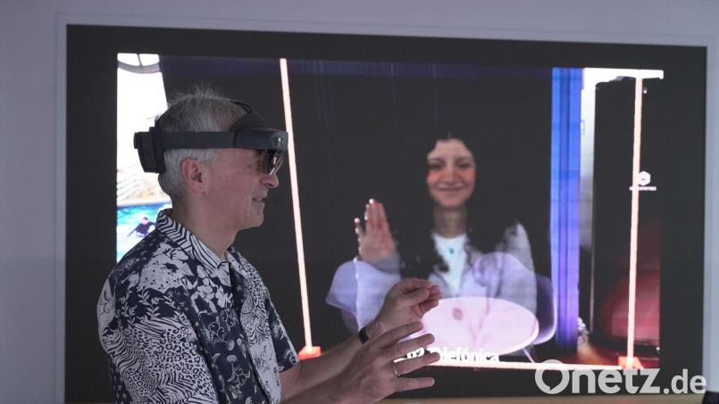 O2-Innovationsmanager Karsten Erlebach spricht via VR-Brille mit seiner Kollegin, die er in der Brille plastisch als Hologramm sieht. Bild: Barbaros Bulgurcu/o2 Telefonica/dpa
