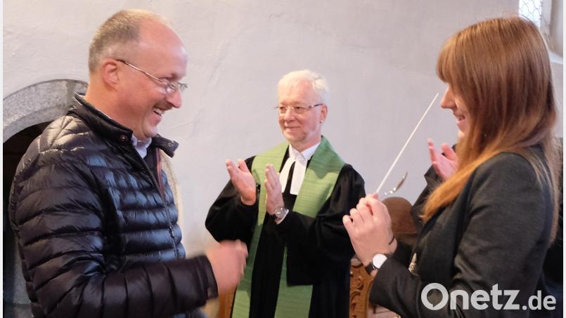 Offiziell übergab Wolfgang Lang (links) an seine Nachfolgerin Tanja Riedel (rechts) den Dirigentenstab worüber sich auch Pfarrer Römischer (Mitte) freute. Bild: le