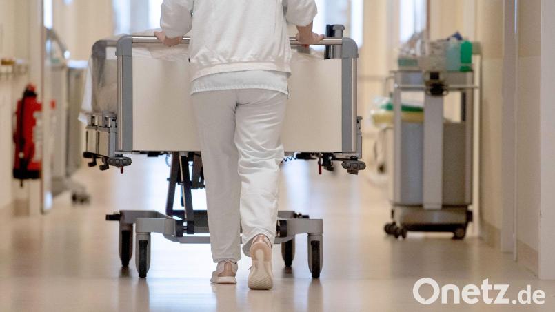 Eine Krankenpflegerin schiebt ein Krankenbett durch einen Flur. In der Pflegebranche sind weiter viele freie Stellen gemeldet. Bild: Marijan Murat/dpa