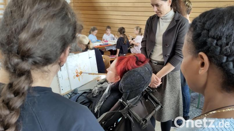 Künstlerin Veronika Svatošová zeigt, wie Mund-Malen funktioniert. Bild: Lebenshilfe Mitterteich/exb