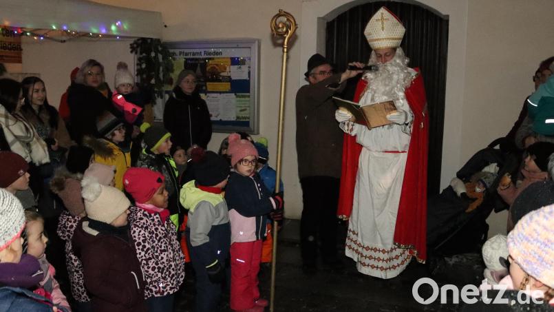 Der heilige Nikolaus erkundigte sich, ob die Riedener Kindergartenkinder anständig gewesen sind. Pfarrer Slawomir Niemczewski (mit Mikro) sorgte für die richtige Lautstärke. Bild: mrr