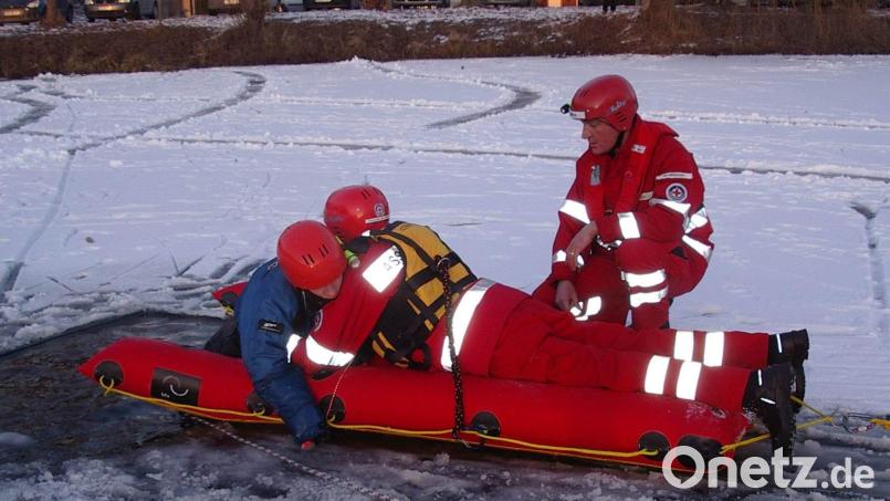 Ein Helfer der Hirschauer Wasserwacht arbeitet sich bei einer Übung mit einem Eisrettungsschlitten an die Einbruchstelle im Mühlweiher vor und befreit das Opfer aus seiner bedrohlichen Lage. Bild: u