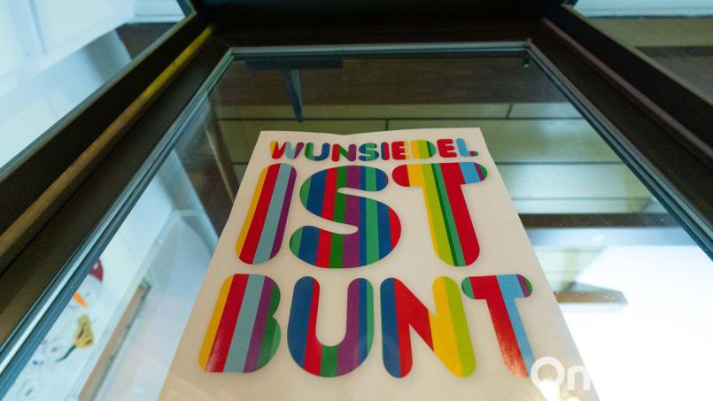 An einer Fensterfront eines Geschäftes ist ein Plakat mit der Aufschrift &quot;Wunsiedel ist bunt&quot; angebracht. Bild: Nicolas Armer/dpa/Archivbild