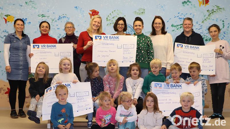 Die Verantwortlichen des Basars mit der Kindergartenleitung und einigen Kindern des Kindergartens, die sich über die fünf Schecks und deren Verwendung freuen. Bild: gru