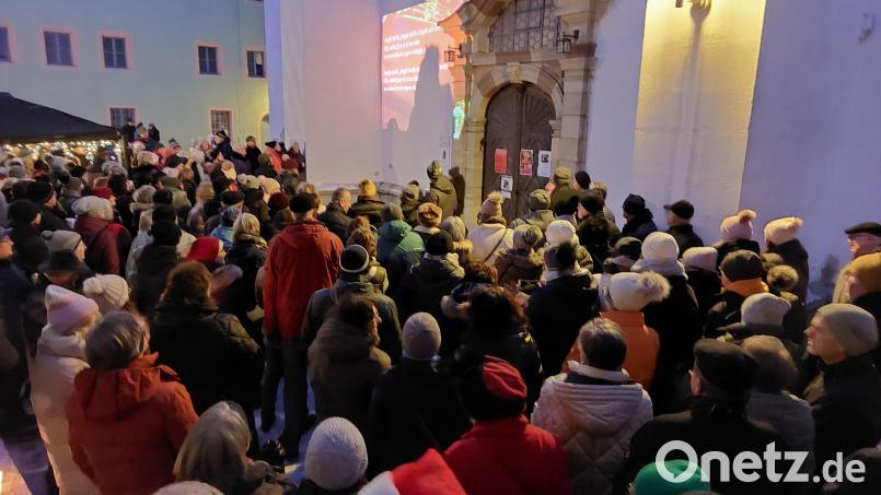 Dicht gedrängt standen die Mitwirkenden des Passanten-Chors vor dem Portal der Michaelskirche und sangen Weihnachtslieder. Bild: Kunz