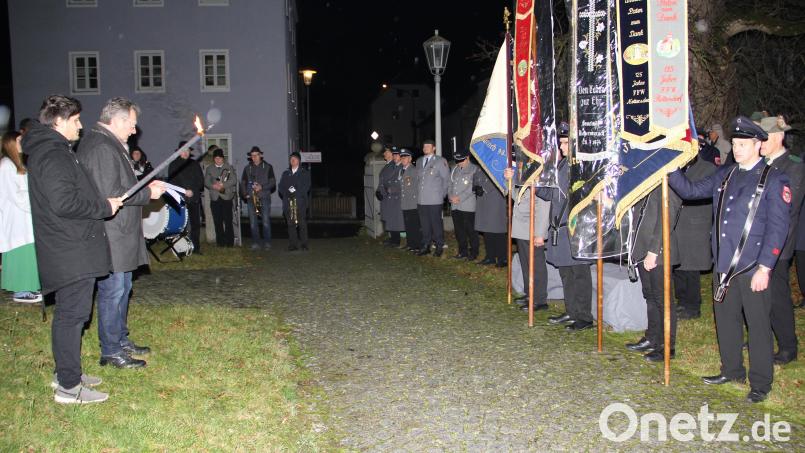 Im Schein der Fackel richtete Bürgermeister Martin Prey am Gefallenendenkmal vor der Kirche eindringliche Worte an die Anwesenden. Bild: Josef Böhm