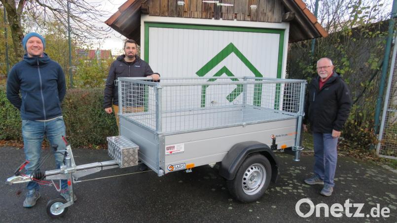 Den neuen Anhänger präsentierten Gerrit Kreuzer (Künstler der Garagentorgrafik und Kassier), Manuel Gössl (1. Vorstand), Klaus Leipold (Gerätewart) vor der mit neuen Logo gestalteten Garage. Bild: adj