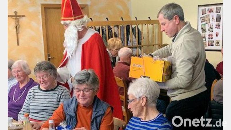 Der Nikolaus verteilt beim Seniorennachmittag Geschenke mit Pfarrer Werner Sulzer. Bild: bjo
