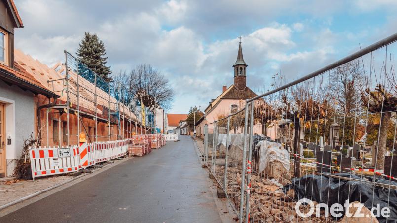 Schon mit Städtebaufördermitteln bezuschusst wurde die Neugestaltung der Philipp-Mühlmayer-Straße. Dort entsteht gerade die Quartiersgarage (links) und die Friedhofsmauer wird neu aufgemauert (rechts). Bild: Susanne Forster