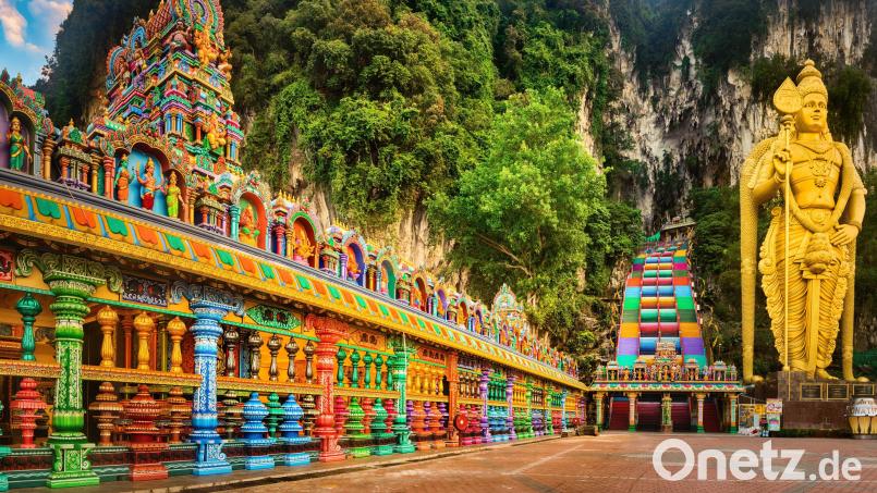 Farbenfrohe Stufen führen zum Eingang der Höhlen - davor steht die vergoldete Statues des Gottes Murugan. Bild: Khoroshunova/Tourism Malaysia/dpa