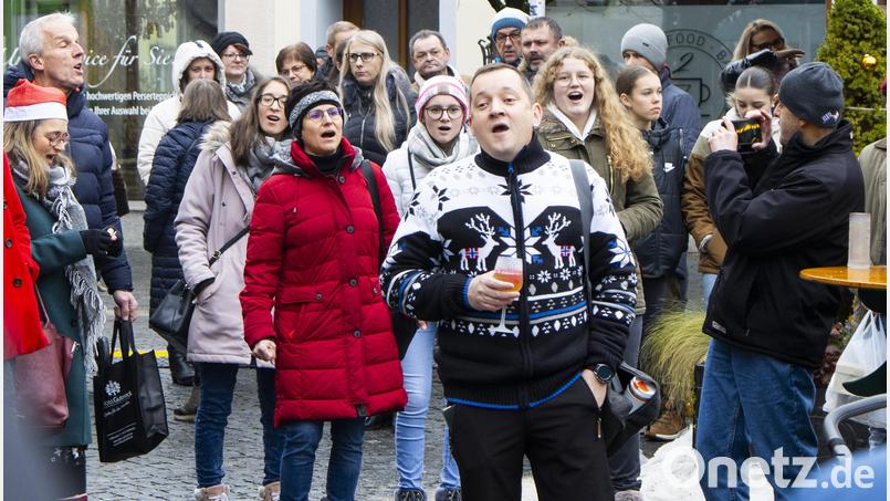 Gezückte Handys und staunende Passanten bringt der zweite Flashmob des Flosser Chores &quot;All Generations&quot; hervor. Im NOC und wie im Bild auf dem Christkindlmarkt singen 30 Sänger ein spontanes Weihnachtsmedley. Bild: All Generations / Michael Birkhan/exb