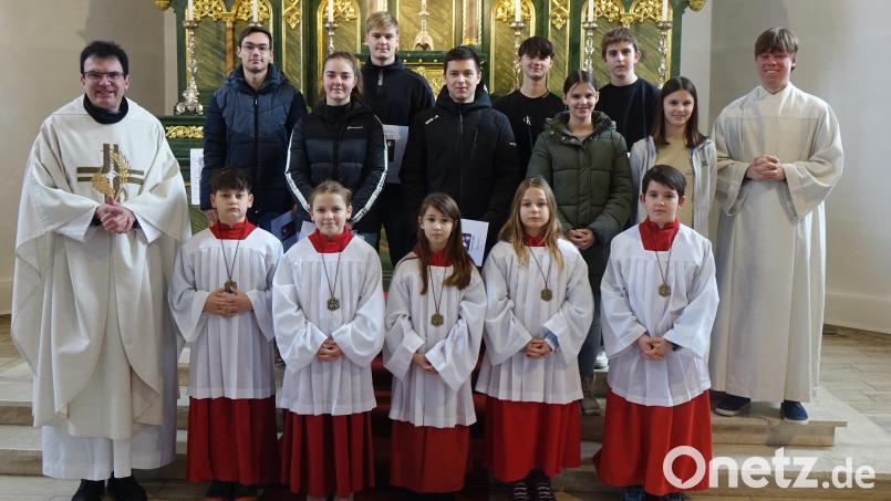Pfarrer Wolfgang Dietz (links) und Gemeindereferent Christian Glaser (rechts) verabschieden die langjährigen Ministranten und begrüßen die &quot;Neuen&quot;. Bild: Christian Glaser/exb