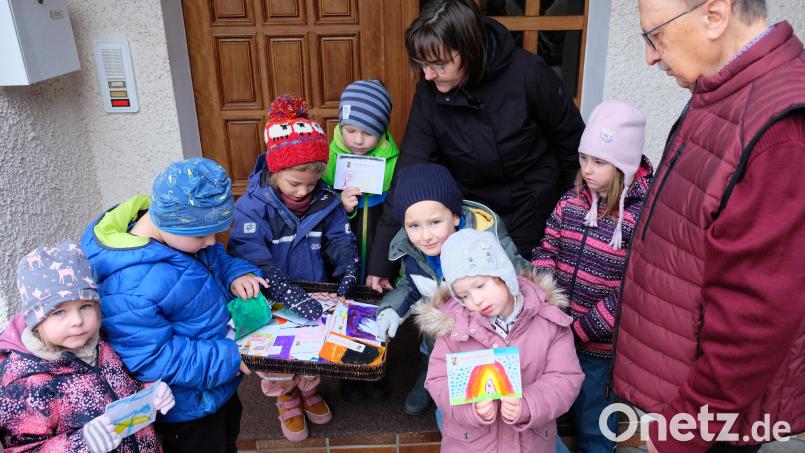 Im Namen der Kita Speinshart überreichte eine fröhliche Kinderschar mit Erzieherin Alexandra Gittler an Andreas Steinl die beim Martinszug gesammelten bunt bemalten Spendenkuverts. Beim Öffnen war die Freude groß, als Steinl beim Nachzählen auf eine Spendensumme von 837 Euro kam Bild: do