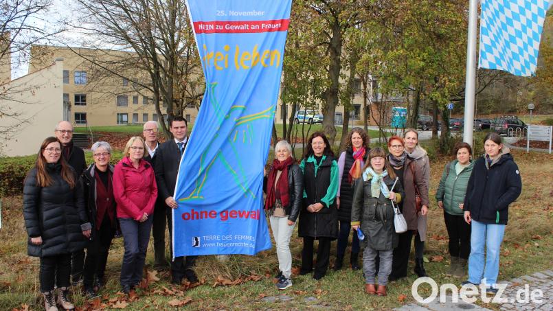Landrat Thomas Ebeling und Kooperationsbeteiligte hissen am Landratsamt die Flagge zum Gedenktag „Nein zu Gewalt an Frauen“. Bild: Prechtl/LAA Schwandorf/exb