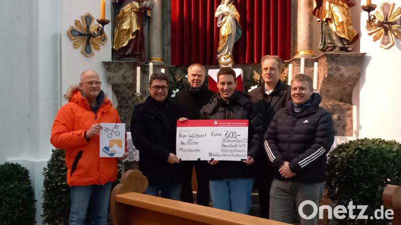 Die Kolpings-Nikoläuse Oliver Völkl, Armin Aichinger, Reiner Hetz (von links), Martin Schmidberger und Wolfgang Huber (von rechts) überreichen an Oberministrant Alexander Schmid (Dritter von rechts) einen Spendencheck in Höhe von 600 Euro für die Rom-Wallfahrt 2024. Bild: Maria Gleißner