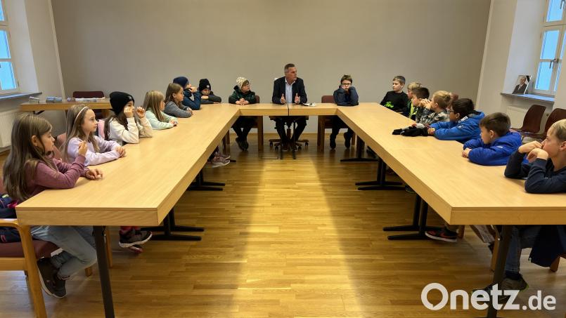 Auf den Plätzen der Gemeinderäte nehmen die Grundschüler Platz und stellen Bürgermeister Norbert Eckl ihre Fragen. Bild: Grundschule Teunz/exb