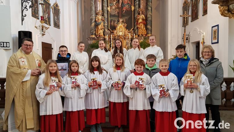 Strahlende Gesichter gab es bei der Neuaufnahme von sieben Ministrantinnen und Ministranten in der Wieskirche. Pfarrer Udo Klösel (links) und Pfarrgemeinde-Sprecherin Elisabeth Völkl (rechts) gratulierten. Bild: gi