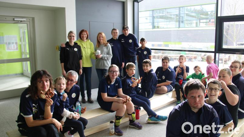 Gabriele Striegl (stehend Zweite von links) übergab an Vorsitzende Carina Völkl (stehend Dritte von links) und ihr Vorstandsteam ein prall gefülltes Sparschwein, mit dem sie Spenden für das Team Bananenflanke Nordoberpfalz gesammelt hatte. Zudem spendierte sie den Fußballern eine Brotzeit. Bild: prh