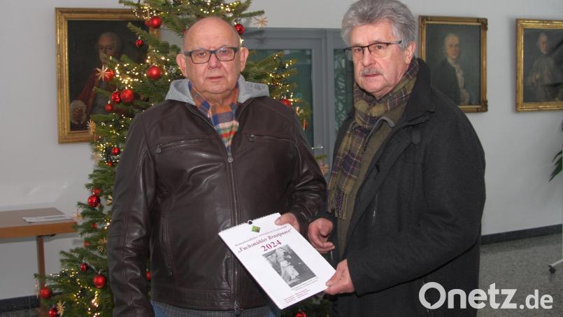 Der von Erich Schraml (links) gestaltete und vom Heimatkundlichen Arbeitskreis Fuchsmühl herausgegebene Kalender 2024 trägt den Titel „Fuchsmühler Brautpaare“. Das erste Exemplar erhielt Bürgermeister Wolfgang Braun. Bild: wro