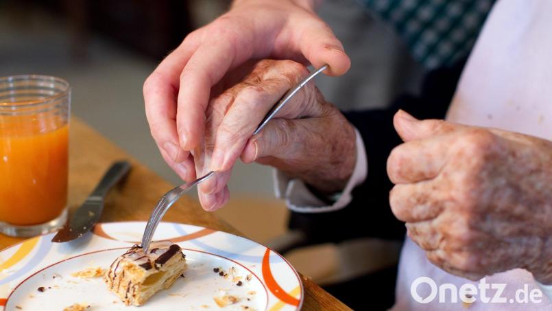 Ein junger Mann, der ein Freiwilliges Soziales Jahr absolviert, hilft einer Bewohnerin einer Wohngemeinschaft für Demenzkranke. Symbolbild: Friso Gentsch/dpa