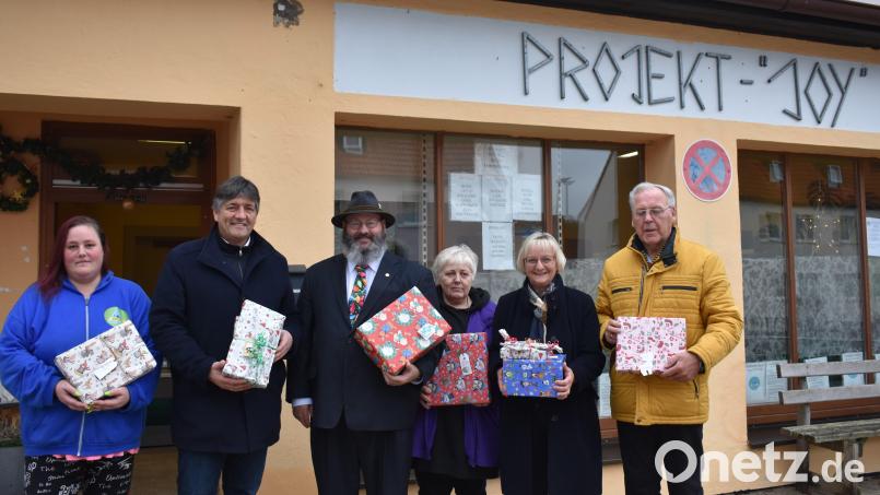 Die Leiterin des Bürgerladens, Monika Sebald (Dritte von rechts), nimmt die Überraschungspäckchen von Barbara Meier (Zweite von rechts) und John Sturz (mit Hut) entgegen. Bild: rgr