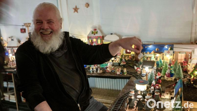 Horst Gründel sitzt vor seinem rund acht Quadratmeter großen Miniatur-Weihnachtsmarkt. Bild: Pia Bayer/dpa