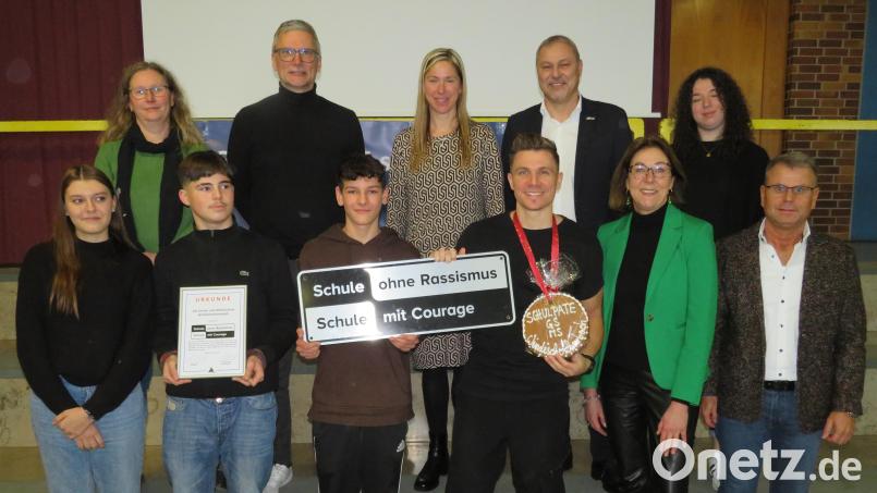 Beim Aktionstag überreichte Jürgen Preisser (hinten, Zweiter von rechts) die Ernennungsurkunde und das Schild für die Schule an die Schülersprecher und Schulleitung. Die Patenschaft übernahm Autor Christian Krömer(vorne, Dritter von rechts). Bild: adj