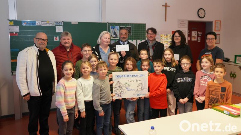 Die gewonnene Dorfheldenwette bringt 3000 Euro für die Waldthurner Schule und Kita. Die Schülerinnen und Schüler der dritten Klasse freuen sich über den Gewinn, den Markus Windisch (hinten, Dritter von rechts) von der Bayernwerk Netz GmbH übergibt. Bild: fvo