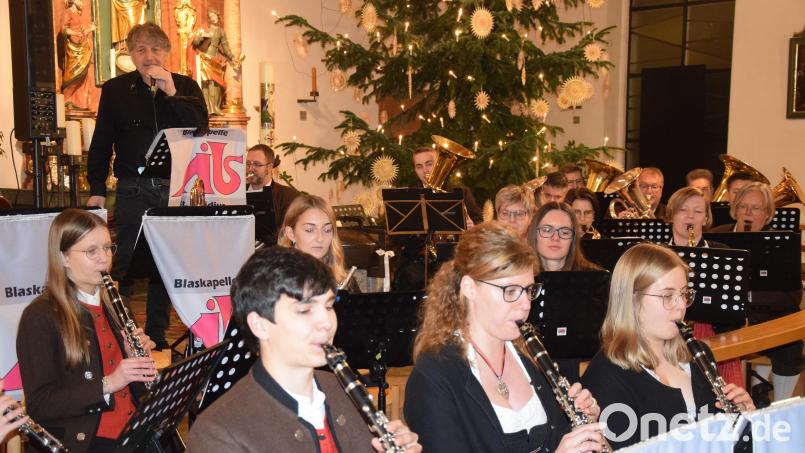Beim Weihnachtskonzert beeindrucken die Blaskapelle St. Ägidius und Sänger Chris Gardner (hinten links) die Zuhörer. Bild: bö