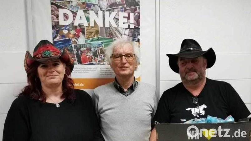 Iris Engelhardt (links) und Georg Deinzer von den Happy Free Liners überreichen an Bernhard Saurenbach von der Amberger Tafel eine Spende von 200 Euro und ein Lebensmittelpaket. Bild: rha